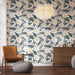 Une pièce lumineuse avec un papier peint floral aux grandes feuilles vertes et fleurs blanches, créant une atmosphère tropicale et apaisante.