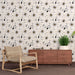 Une pièce moderne avec un papier peint floral blanc et noir, orné de grandes fleurs délicates et de touches dorées, créant une ambiance élégante et apaisante.