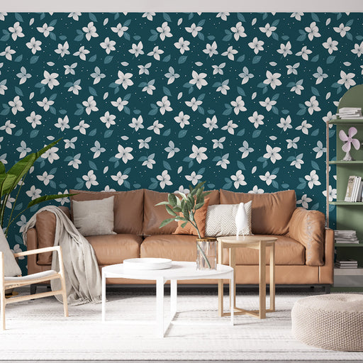 Un salon moderne avec un papier peint floral bleu canard orné de fleurs blanches et de feuilles vertes, créant une ambiance fraîche et accueillante.
