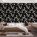 Une chambre moderne avec un papier peint floral aux fleurs blanches sur fond noir, créant une atmosphère élégante et chaleureuse.