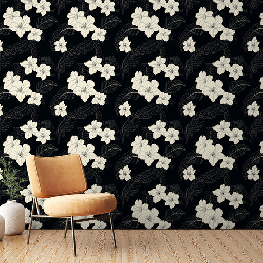 Un salon moderne avec un papier peint floral noir et blanc, orné de grandes fleurs et de feuilles, créant une ambiance élégante et sophistiquée.
