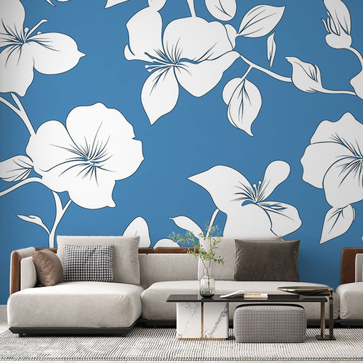 Un salon moderne avec un papier peint floral blanc sur fond bleu vif, créant une ambiance fraîche et dynamique.