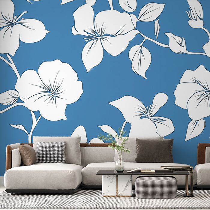 Un salon moderne avec un papier peint floral blanc sur fond bleu vif, créant une ambiance fraîche et dynamique.