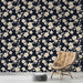 Une chambre moderne avec un papier peint floral crème sur fond bleu nuit, créant une ambiance élégante et apaisante.