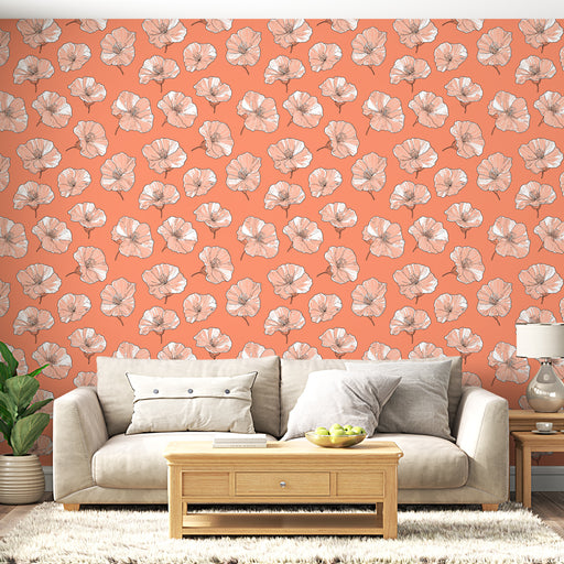 Un salon lumineux avec un papier peint floral aux grandes fleurs blanches sur fond corail, créant une ambiance chaleureuse et accueillante.