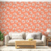 Un salon lumineux avec un papier peint floral aux grandes fleurs blanches sur fond corail, créant une ambiance chaleureuse et accueillante.