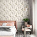 Une chambre élégante avec un papier peint floral aux motifs délicats de fleurs et de branches sur fond crème, créant une atmosphère apaisante et raffinée.