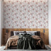 Une chambre élégante avec un papier peint floral aux motifs délicats de fleurs roses sur fond clair, créant une atmosphère douce et apaisante.