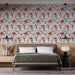 Une chambre moderne avec un papier peint floral aux motifs de fleurs orange et feuilles grises sur fond clair, créant une atmosphère chaleureuse et accueillante.