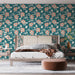 Une chambre moderne avec un papier peint floral turquoise orné de grandes fleurs roses et de feuillages, créant une ambiance fraîche et accueillante.