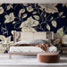 Une chambre moderne avec un papier peint floral crème sur fond bleu marine, créant une atmosphère élégante et apaisante.
