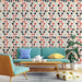 Un salon lumineux avec un papier peint aux motifs floraux stylisés en noir, rouge et beige sur fond clair, créant une ambiance moderne et chaleureuse.