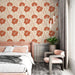 Une chambre élégante avec un papier peint floral aux grandes fleurs rouges sur fond beige, créant une atmosphère chaleureuse et accueillante.