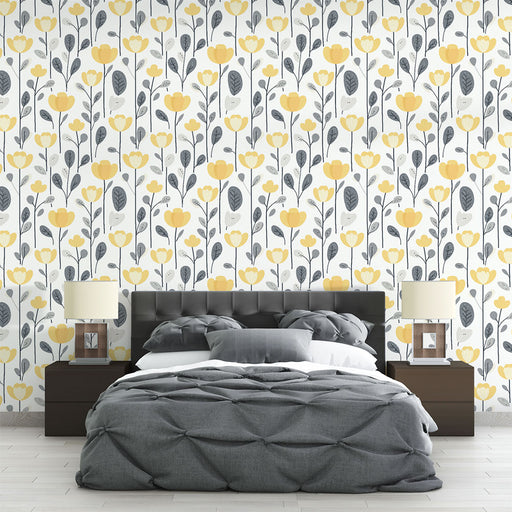 Une chambre moderne avec un papier peint floral aux motifs de fleurs jaunes et feuillages gris sur fond blanc, créant une ambiance fraîche et joyeuse.