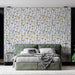 Une chambre moderne avec un papier peint floral blanc orné de fleurs jaunes et de tiges noires, créant une atmosphère fraîche et accueillante.