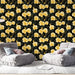 Une pièce moderne avec un papier peint floral jaune sur fond noir, créant une ambiance chaleureuse et accueillante, agrémentée de fauteuils confortables.