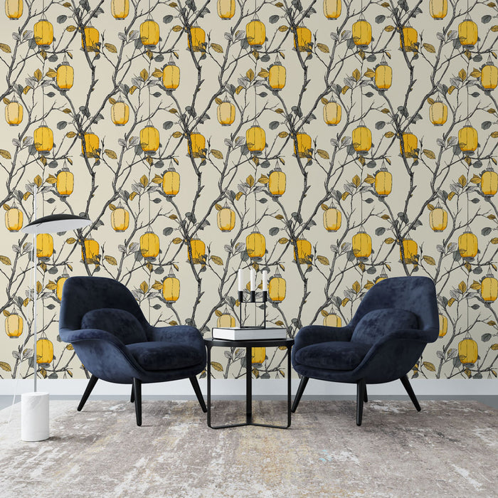 Un salon élégant avec un papier peint floral aux motifs de branches noires et de fruits jaunes sur fond crème, créant une atmosphère chaleureuse et accueillante.