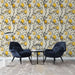 Un salon élégant avec un papier peint floral aux motifs de branches noires et de fruits jaunes sur fond crème, créant une atmosphère chaleureuse et accueillante.