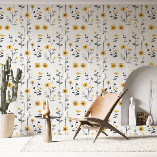 Une pièce lumineuse avec un papier peint floral aux motifs jaunes et gris sur fond clair, évoquant une atmosphère joyeuse et accueillante.