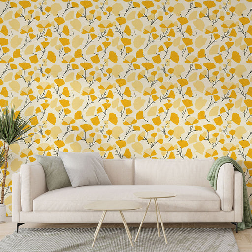 Une pièce lumineuse avec un papier peint floral jaune et crème, orné de délicates branches, créant une atmosphère joyeuse et accueillante.