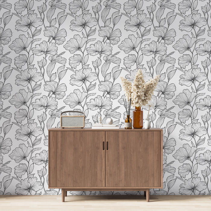 Une salle de séjour élégante avec un papier peint floral noir et blanc aux motifs délicats, créant une ambiance artistique et apaisante.