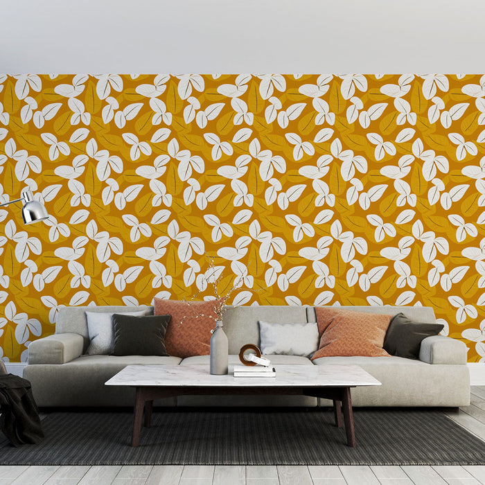 Un salon contemporain avec un papier peint floral aux motifs de feuilles blanches sur fond jaune, créant une ambiance chaleureuse et dynamique.