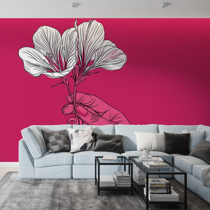 Un salon moderne avec un papier peint fuchsia illustrant une main tenant des fleurs blanches, créant une ambiance artistique et vibrante.