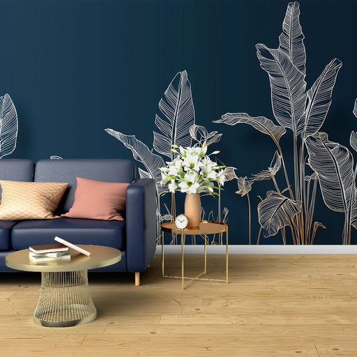 Une pièce moderne avec un papier peint tropical bleu nuit illustrant des feuilles exotiques blanches, créant une ambiance élégante et apaisante.