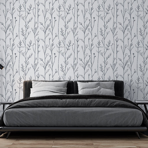 Une chambre moderne avec un papier peint floral en noir et blanc représentant des branches délicates, créant une atmosphère apaisante et élégante.