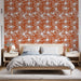 Une chambre moderne avec un papier peint terracotta orné de fleurs blanches stylisées, créant une ambiance chaleureuse et accueillante.