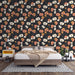 Une chambre moderne avec un papier peint floral sur fond noir, aux motifs de fleurs dans des teintes de rose, beige et orange, créant une ambiance chaleureuse et accueillante.