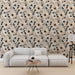 Un salon moderne avec un papier peint floral aux teintes douces de beige, noir et blanc, créant une atmosphère élégante et apaisante.