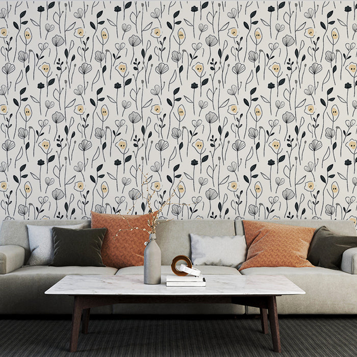 Un salon moderne avec un papier peint floral en noir et blanc, agrémenté de touches jaunes, créant une ambiance douce et élégante.