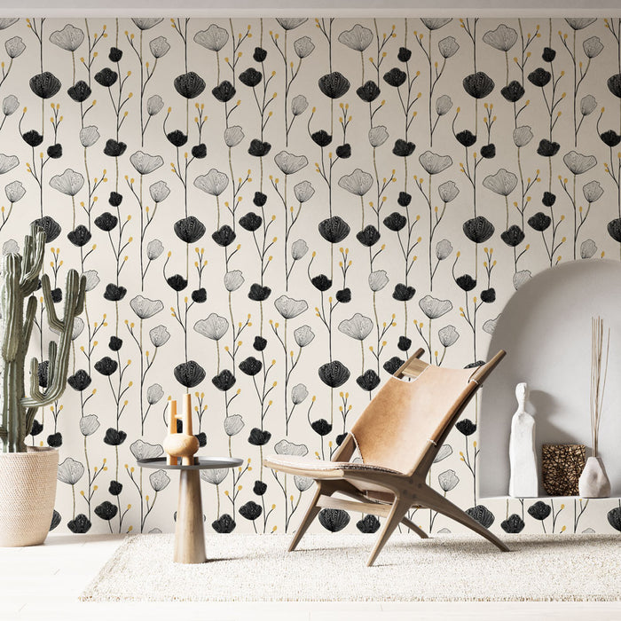 Une pièce moderne avec un papier peint floral en noir, blanc et touches dorées, créant une atmosphère élégante et artistique.