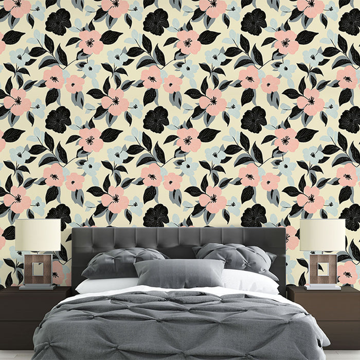 Une chambre élégante avec un papier peint floral aux motifs roses, bleus et noirs sur fond crème, créant une atmosphère douce et accueillante.