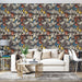 Un salon moderne avec un papier peint floral aux motifs colorés de feuilles dans des teintes de bleu, orange et jaune sur fond sombre, créant une ambiance chaleureuse et dynamique.