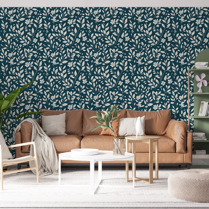 Un salon moderne avec un papier peint floral bleu marine orné de motifs de feuilles et de fleurs blanches, créant une atmosphère fraîche et accueillante.