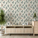 Une pièce moderne avec un papier peint floral aux motifs de feuillage vert et de petites fleurs corail sur fond crème, créant une atmosphère chaleureuse et accueillante.