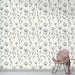 Une pièce lumineuse avec un papier peint floral aux motifs délicats en noir sur fond crème, créant une atmosphère apaisante et élégante.