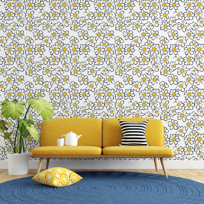 Un salon lumineux avec un papier peint floral aux motifs de marguerites blanches et jaunes sur fond clair, créant une ambiance joyeuse et accueillante.