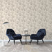 Un salon élégant avec un papier peint floral beige aux délicates illustrations noires de fleurs, créant une atmosphère douce et apaisante.