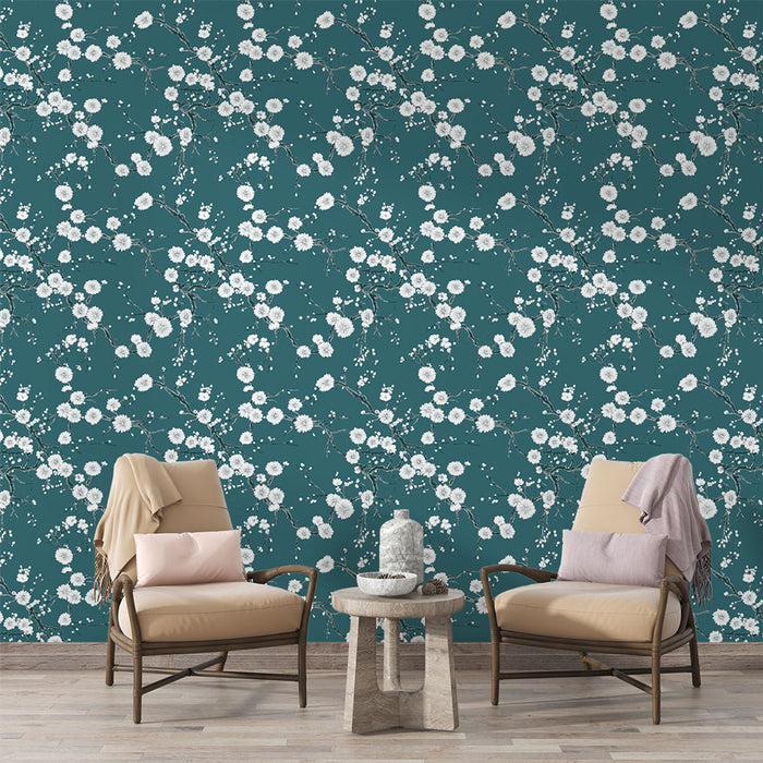Un salon élégant avec un papier peint floral bleu canard orné de délicates fleurs blanches, créant une atmosphère apaisante et naturelle.