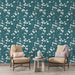 Un salon élégant avec un papier peint floral bleu canard orné de délicates fleurs blanches, créant une atmosphère apaisante et naturelle.