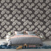 Une chambre élégante avec un papier peint floral noir et blanc aux motifs de fleurs stylisées, créant une atmosphère chic et apaisante.