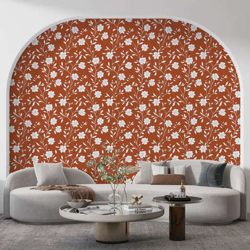 Un salon contemporain avec un papier peint floral rouge brique orné de motifs blancs évoquant une atmosphère chaleureuse et accueillante.