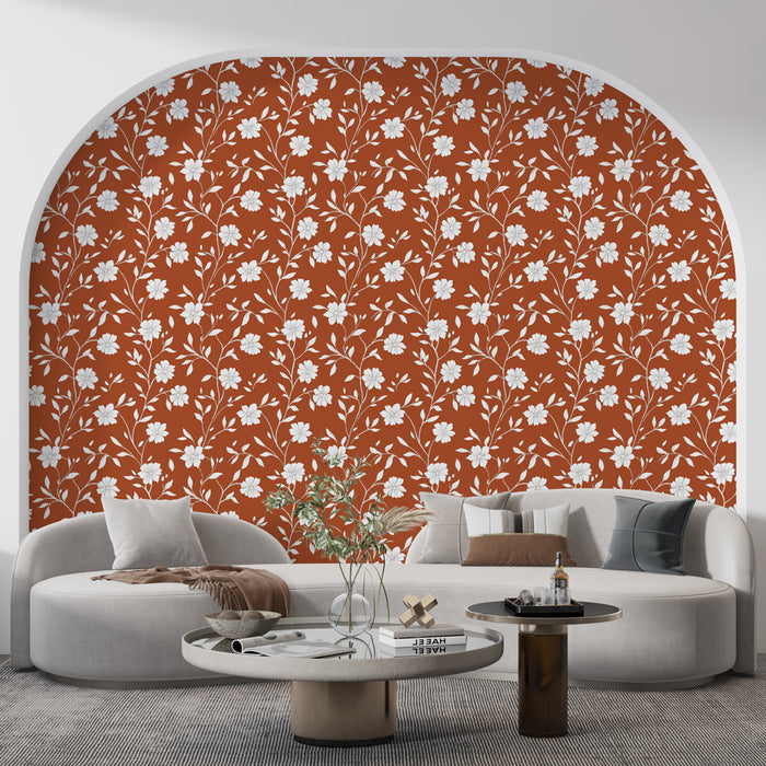 Un salon contemporain avec un papier peint floral rouge brique orné de motifs blancs évoquant une atmosphère chaleureuse et accueillante.