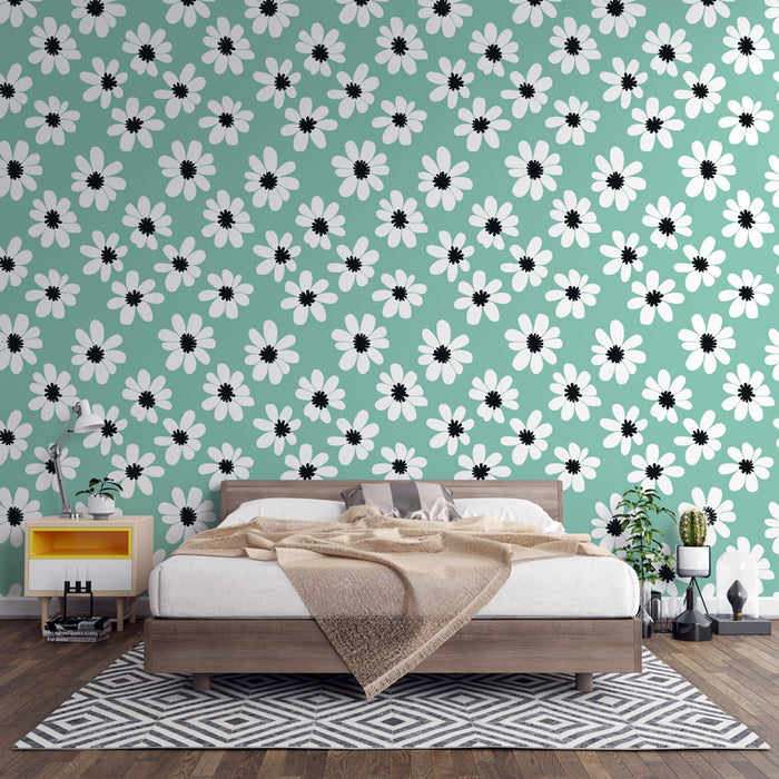 Une chambre accueillante avec un papier peint floral vert menthe orné de grandes fleurs blanches et noires, créant une atmosphère fraîche et joyeuse.