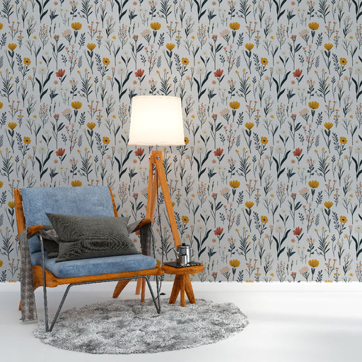 Un salon lumineux avec un papier peint floral aux motifs colorés de fleurs jaunes, roses et vertes sur fond clair, créant une ambiance fraîche et accueillante.