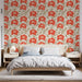 Une chambre accueillante avec un papier peint floral aux grandes fleurs rouges sur fond crème, créant une atmosphère chaleureuse et vivifiante.