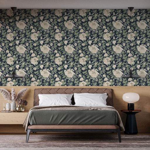 Une chambre élégante avec un papier peint floral bleu marine aux motifs délicats de fleurs crème et vertes, créant une atmosphère chaleureuse et apaisante.